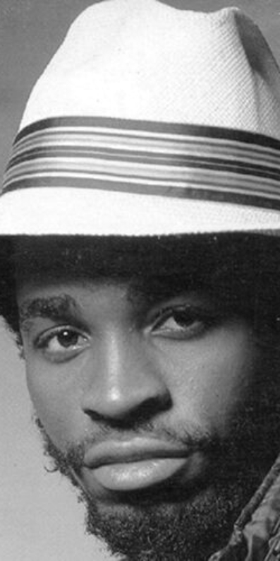 Male artist wearing a hat staring into camera
